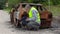 Inspector talking on smart phone near burned down car wreck on the side of the road