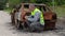 Inspector using tablet PC near burned down car wreck on the side of the road