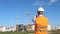 Inspector in a white helmet and an alarm jacket is photographing the construction of an apartment house