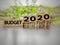 inspirational and conceptual - budget 2020 on wooden blocks with coins stack  in blurred motion background