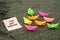 Inspirational motivational quote - Find your happiness. With group of colorful origami paper boats as an illustration.