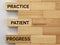 Inspirational Quote - practice patient progress text on wooden blocks background. Stock photo.