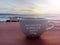 Inspirational quote and text wishes - may your week be filled with positive energy. Text on white cup on red table in the beach.