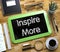 Inspire More - Text on Small Chalkboard. 3D.