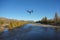 Inspire quadcopter drone flying over river. back view