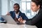 Inspired African American businessman wearing formal suit talking to colleague