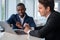 Inspired African American businessman wearing formal suit talking to colleague