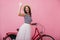 Inspired brunette woman in striped tank-top posing with red bicycle. Blithesome tanned lady standin