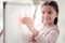 Inspired creative schoolgirl sticking pink paper notes on whiteboard