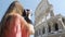 Inspired female photographer taking picture of Colosseum amphitheater in Rome