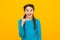 Inspired happy teen girl with braided hair has an idea on yellow background, creativity