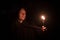 Inspired male portrait with candle in hand night time story concept picture in darkness environment, soft focus on face and noise