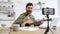 Inspired man playing guitar while recording video on mobile