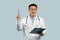 Inspired middle aged chinese male doctor in white coat and glasses with tablet rising pen up