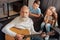 Inspired senior man playing guitar for his grandchildren