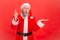 Inspired thoughtful elderly man in santa claus costume pointing finger up, has good idea about holidays celebration, solution