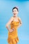 Inspired woman playfully posing on blue background. Amazing pinup lady in short dress enjoying photoshoot