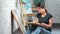 Inspired young charming female painter drawing picture on canvas at art studio