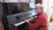 Inspirited senior woman plays piano music in light room