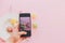 instagram blogging concept, flat lay. food photography. hand holding phone and taking photo of stylish colorful macaroons in