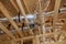 Installation of a central conditioning HVAC system highlights wooden beamed ceiling in new home.