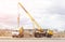 Installation and construction of lighting lamps on the new road using a truck crane and cement truck, the sun, copy space building