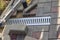 Installation of light metal grating and gutters for drainage of rainwater and paving slabs. Selective focus