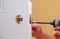 Installation locked interior door knobs, close-up woodworker hands install lock