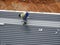 Installation of metal deck roof sheet by construction workers.