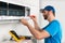 Installation service fix  repair maintenance of an air conditioner indoor unit by cryogenist technican worker with screwdriver