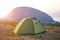 Installed tourist tent in the mountains with a view of the sea and sunrise. Domestic tourism, active summer trip, family