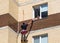 Installers work on the wall of a residential house