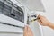 Installing an air conditioner in an apartment office, close-up of an engineer hand