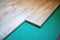 Installing wooden laminate or parquet floor in room over green noise absorbing base, close-up