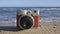 An instant camera captures the vast blue sea, its waves crashing against the shore.