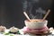 Instant noodles and spoon with wooden fork in cup with smoke rising and garlic on dark background, Sodium diet high risk kidney f