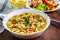 Instant noodles in white bowl on wooden table background and vegetables salad