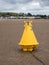 INSTOW, NORTH DEVON - APRIL 29 2021. Yellow navigational buoy on the sand at low tide.