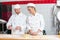 Instructor and apprentice in bakery making pretzels