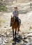 Instructor or cattleman riding horse in sunglasses, cowboy hat and rider boots