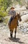 Instructor or cattleman riding horse in sunglasses, cowboy hat and rider boots