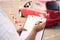 Instructor with clipboard near car outdoors, closeup. Driving school exam