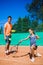 Instructor or coach teaching child how to play tennis on a court indoor