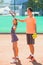 Instructor or coach teaching child how to play tennis on a court indoor