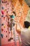 Instructor guiding woman on rock climbing wall