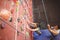 Instructor guiding woman on rock climbing wall