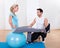 Instructor helping a woman with pilates exercises