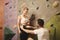 Instructor preparing young woman for climbing