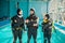 Instructor and two divers in suits, diving school