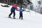 Instructors teach a child skiing